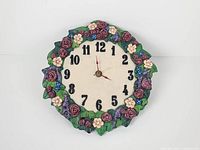 Front view of ceramic wall clock showing floral border and clock face
