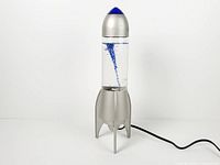 Full view of rocket lamp showing base, reservoir, blue cap and power cord