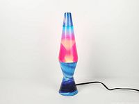 Full view of illuminated Northern Lights lava lamp displaying pink wax and blue liquid