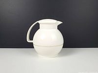 Left profile of spherical white Rotpunkt carafe