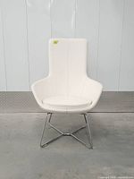 Front view of white leatherette lounge chair showing full design and condition
