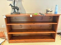Front view of wooden bookcase with three shelves