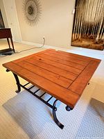 Full view of square wood-top coffee table on carpet