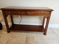 Front view of Broyhill console table showing drawers, shelf, hardware, dimensions context