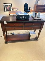 Front view of console table showing drawers, legs, lower shelf