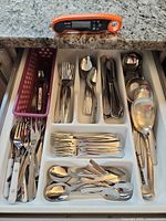 Overall drawer view showing cutlery set and thermometer