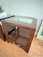 Oblique view showing wood frame, glass top, shelf, drawer