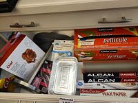 Drawer contents showing wrap boxes, foil, wax paper, beer can chicken roaster packaging, aluminum tray