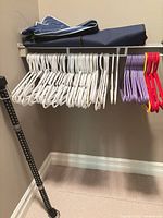 Shelf view with white, purple, red, yellow plastic hangers and folded storage bags