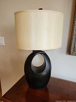 Full view of lamp on table, showing base and shade