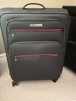 Front view of Air Canada suitcase showing full height, four wheels, front pocket, red piping