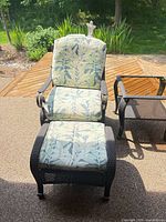 Front view of wicker armchair with matching ottoman and cushions