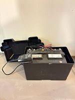 Battery backup system in open plastic case with charger visible