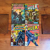 Group shot of all four comic books arranged in 2x2 layout