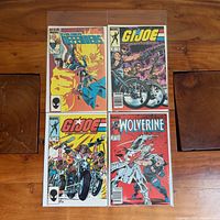 Group shot of four bagged Marvel comic books on wooden surface