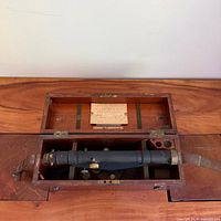 Open wooden box showing telescope level and interior