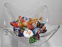 Top view of clear Daum bowl holding many colourful glass candy pieces