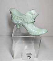 Full left profile of green slag glass cat shoe on clear riser