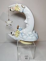 Front view of ceramic crescent moon music box with figures and star