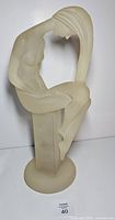 Front view of entire frosted Lucite seated female figure on pedestal