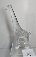 Full view of clear glass giraffe figurine on display stand