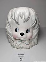 Front view of puppy head planter showing facial features and bow