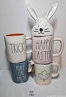 Front view of stacked four mugs showing graphics and text