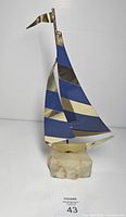 Full view of sailboat sculpture showing sails, mast, quartz base
