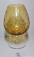 Front view of amber diamond optic brandy snifter