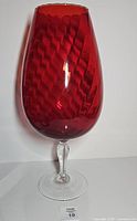 Front view showing full height, red bowl, clear stem, optic pattern
