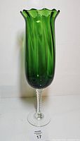 Full view of tall emerald green fluted vase on clear twisted stem