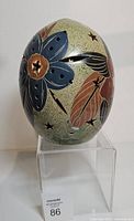 Front view showing flower motif and star cutouts on ceramic egg lantern