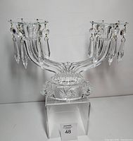 Front view of double-arm crystal candelabra showing overall form and base