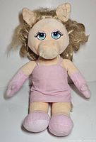 Front view of Miss Piggy puppet plush in pink dress