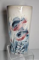 Front view of vase showing embossed fish and aquatic design