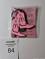 Front view of sealed pink cowboy-boot keychain with McDonald's arches