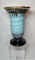 Front view of teal and brown drip glaze vase on pedestal base
