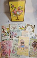 Front view of box lid and spread of assorted greeting cards