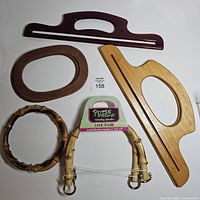 Overview of six assorted handbag handles including bamboo pair, bamboo ring, two wood and one plastic handle