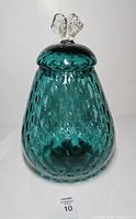Full view of teal Empoli glass cookie jar with lid on