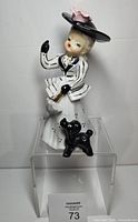 Front view of figurine showing girl, parasol, and poodle