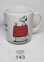 Mug showing Snoopy and Woodstock on red doghouse