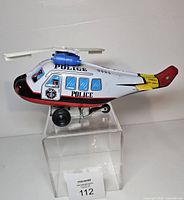 Left side view of tin police helicopter on acrylic riser
