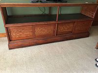 Full view of the antique large wooden jewelry display case showing the glass top without side glass and the front sliding doors.