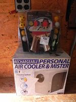 Photo of ping pong set with paddles and balls on top of the boxed O2 Cool Box rechargeable personal air cooler and mister.