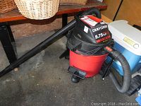 Full view of the red and black Craftsman wet/dry vacuum with attached hoses and an extension wand.
