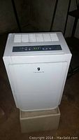 Front view of Friedrich dehumidifier, white with logo on front panel, showing air intake vents.
