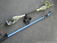 Electric hedge trimmer and blue extendable pole saw with limb cutter laid on ground.