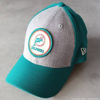 Front view showing heathered grey crown, aqua visor, throwback Dolphins patch and New Era flag