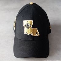 Full view of black New Era Saints cap showing front embroidered Louisiana state logo